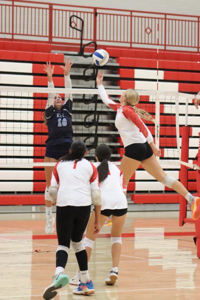 Senior Tori Buss attempts to tip the ball behind the blocker from East.