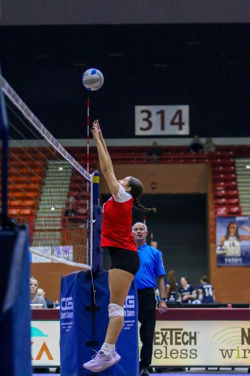 Senior Cora Daggett goes up for a block during pool play of the Class 6A tournament.