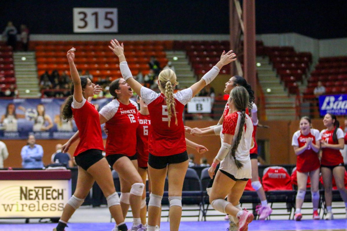 The volleyball team celebrates a point at the Class 6A tournament in Salina. North went 1-2 in pool play.